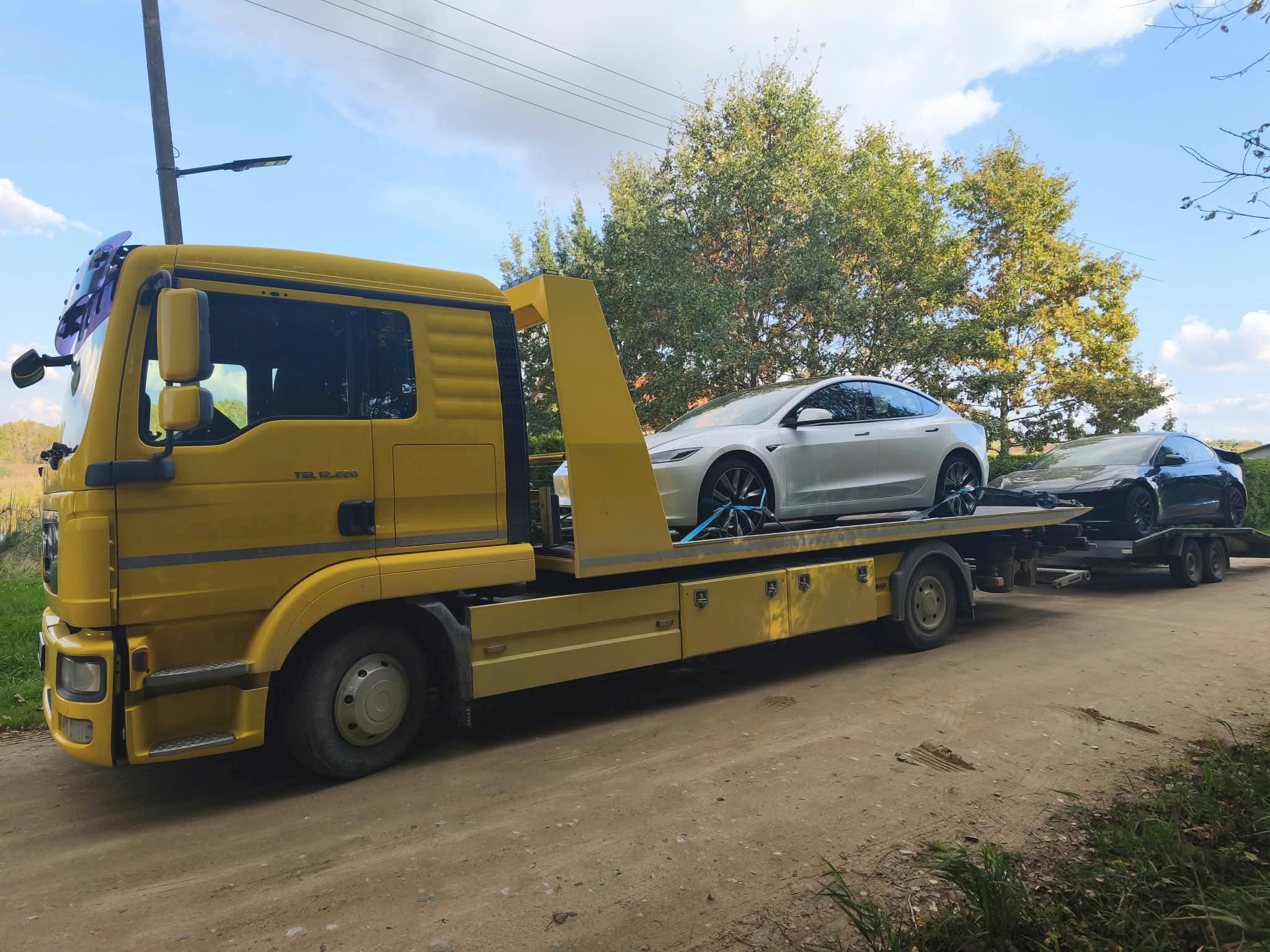 Tralas su ant platformos pakrautu automobiliu